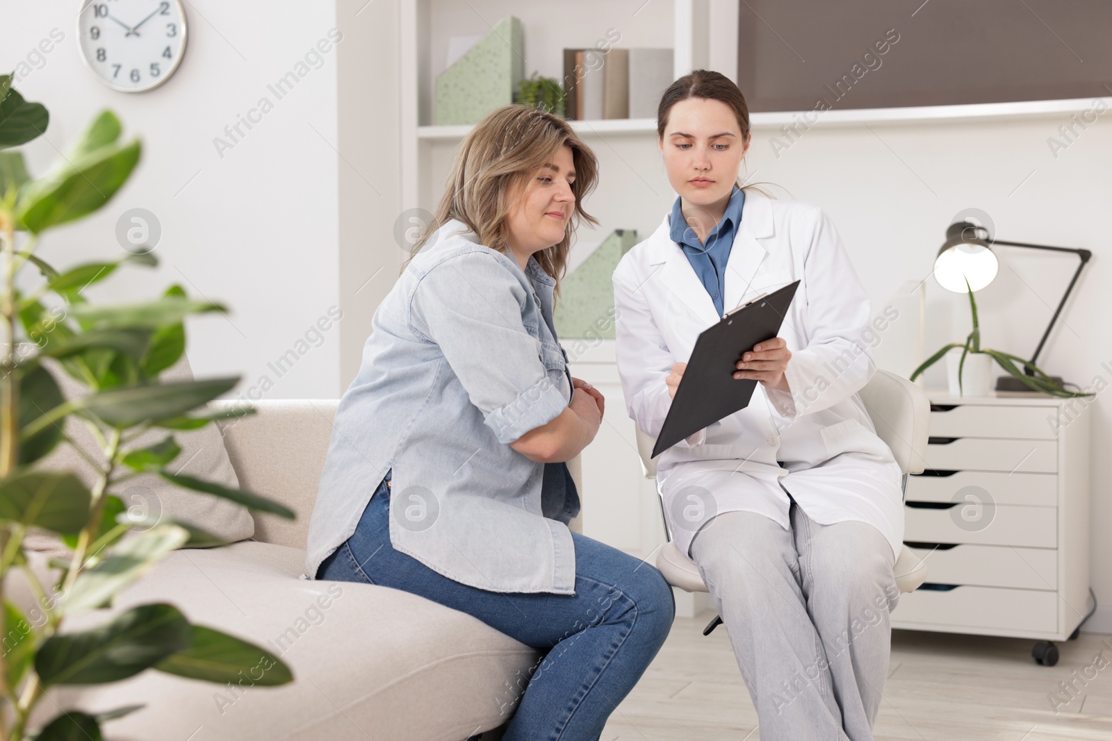 Photo of Weight loss. Nutritionist consulting overweight woman in clinic