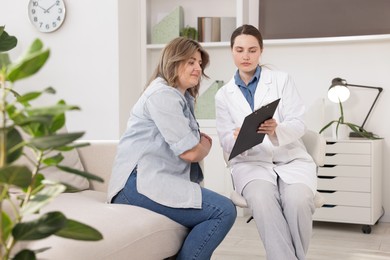 Photo of Weight loss. Nutritionist consulting overweight woman in clinic