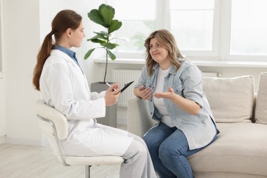 Photo of Weight loss. Nutritionist consulting overweight woman in clinic