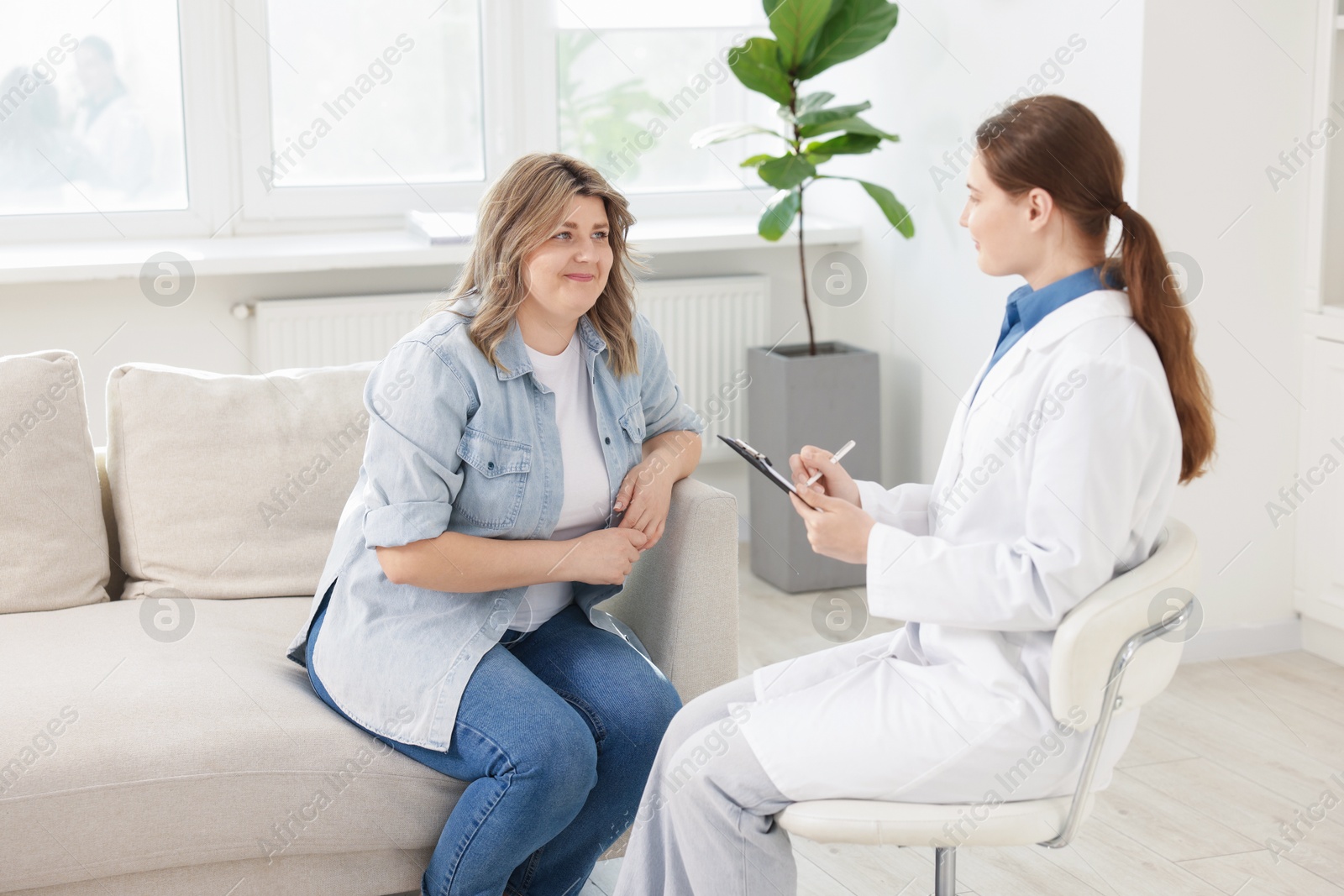 Photo of Weight loss. Nutritionist consulting overweight woman in clinic