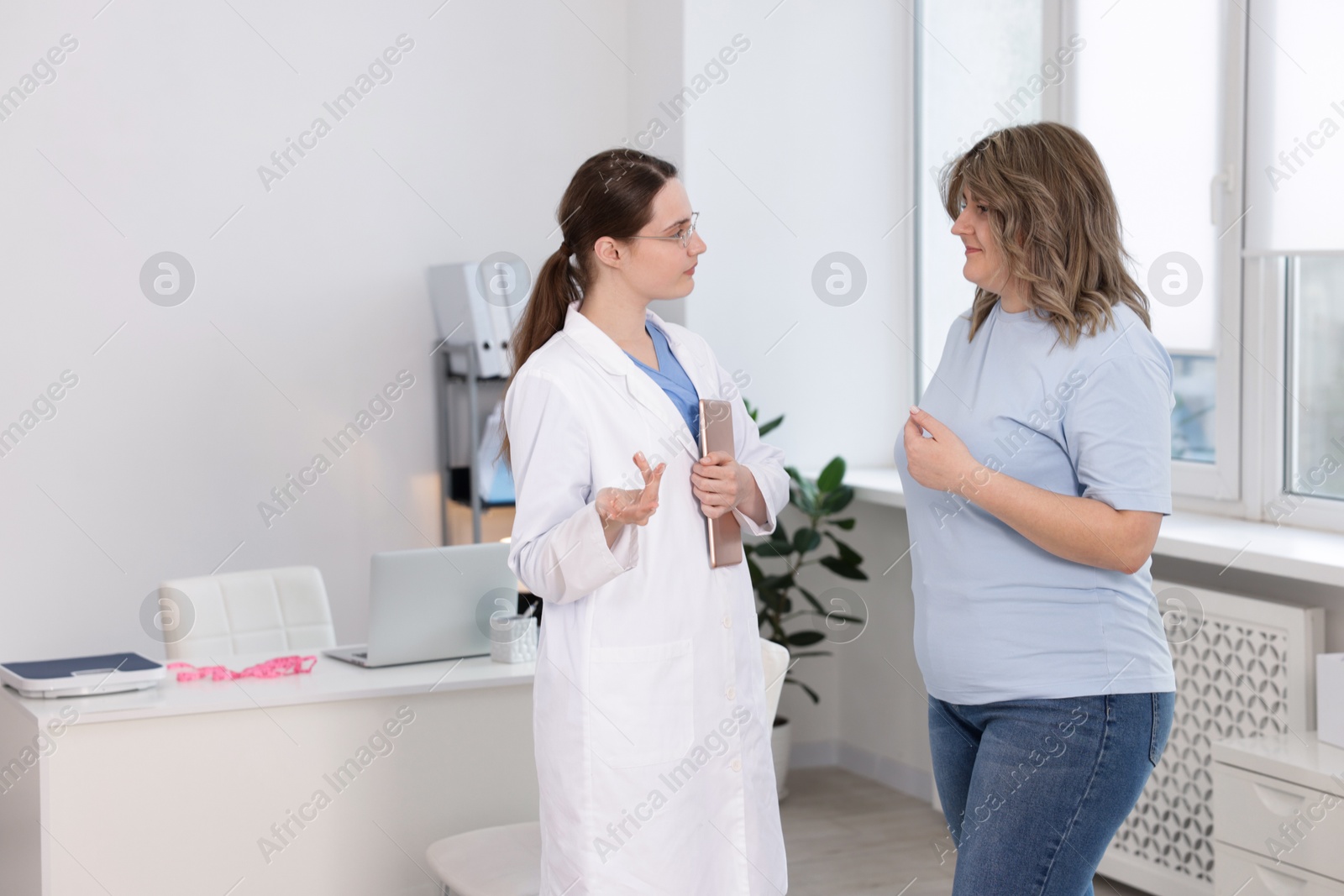 Photo of Weight loss. Nutritionist consulting overweight woman in clinic