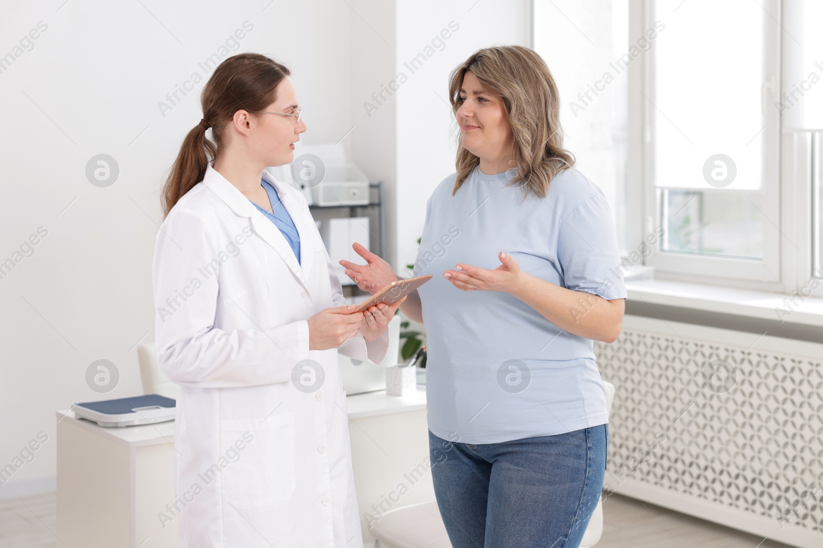 Photo of Weight loss. Nutritionist consulting overweight woman in clinic