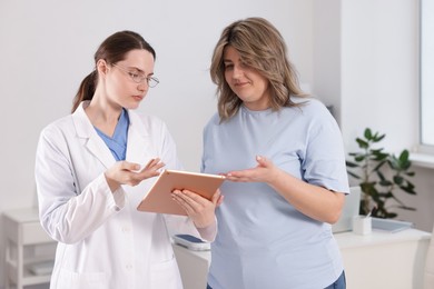 Photo of Weight loss. Nutritionist consulting overweight woman in clinic