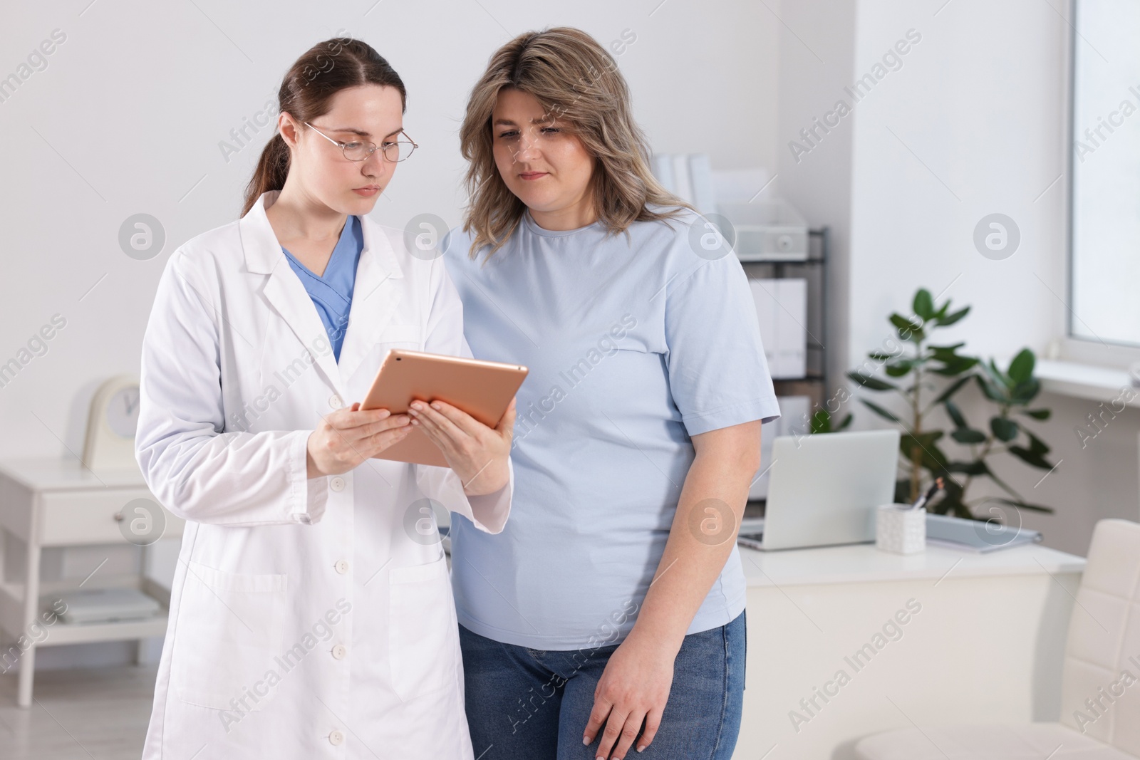 Photo of Weight loss. Nutritionist consulting overweight woman in clinic