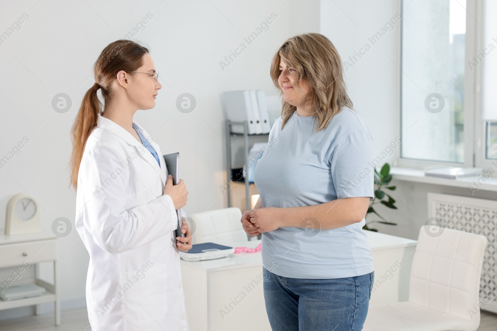 Photo of Weight loss. Nutritionist consulting overweight woman in clinic