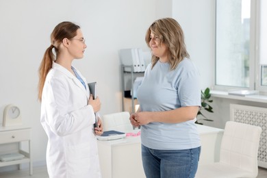 Photo of Weight loss. Nutritionist consulting overweight woman in clinic
