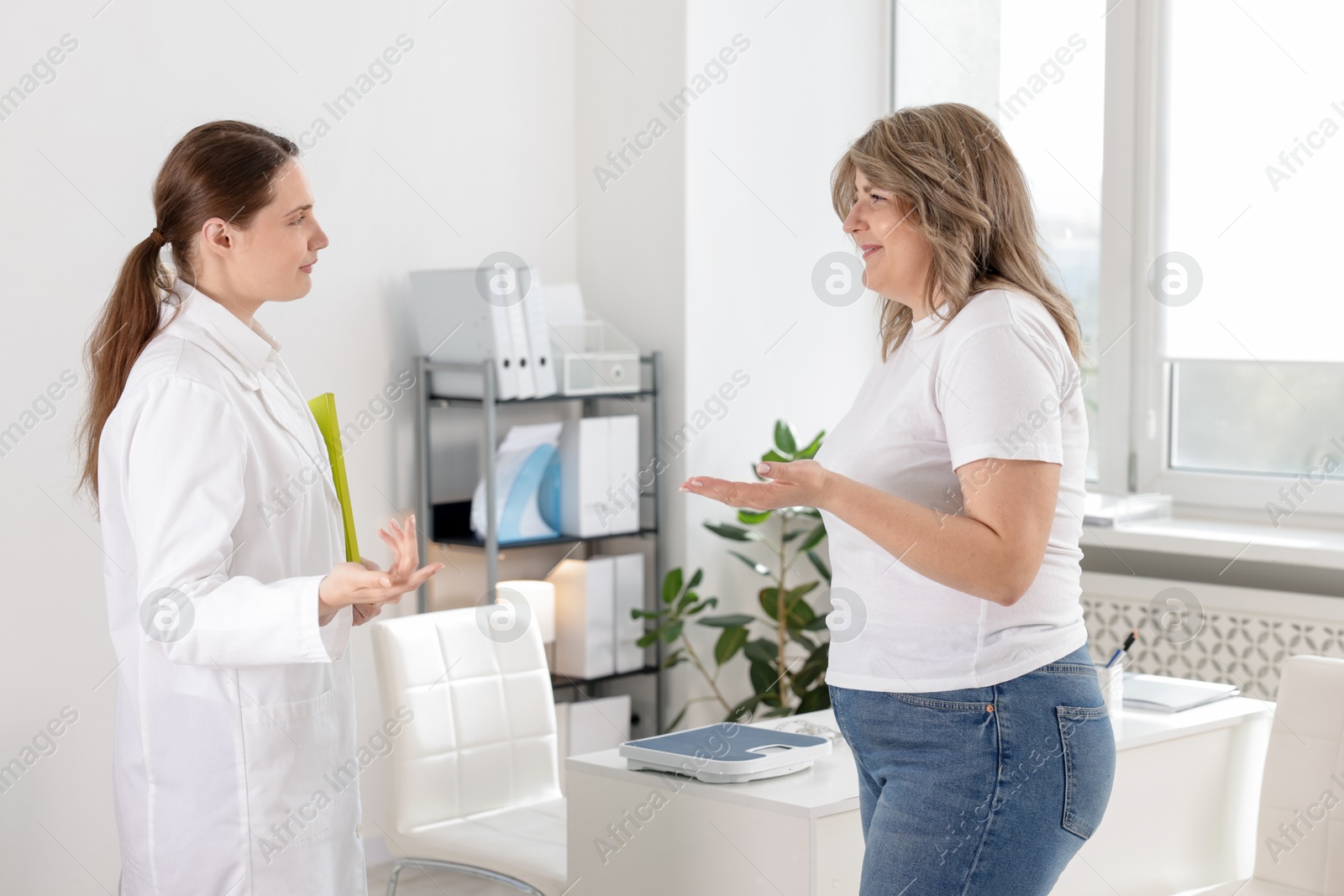 Photo of Weight loss. Nutritionist consulting overweight woman in clinic