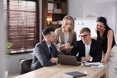 Photo of Marketing. Team of businesspeople working together at desk in office