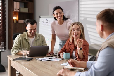Photo of Marketing. Team of businesspeople working together at desk in office