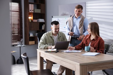 Photo of Marketing. Team of businesspeople working together at desk in office