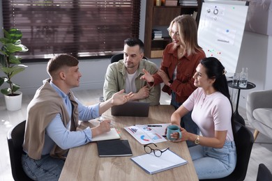 Photo of Marketing. Team of businesspeople working together at desk in office