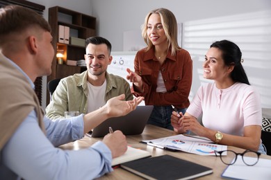 Photo of Marketing. Team of businesspeople working together at desk in office