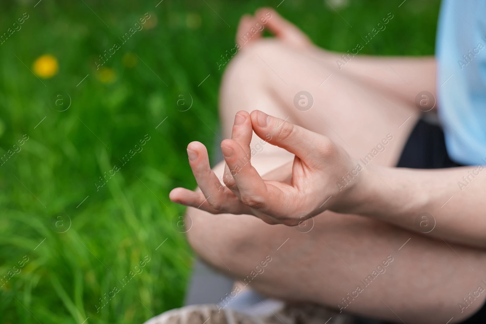 Young man practicing yoga on mat in park, closeup Photo of Young man practicing yoga on mat in park, closeup