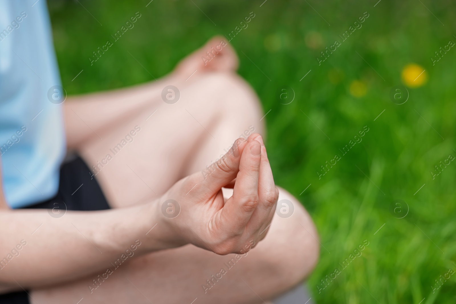 Young man practicing yoga on mat in park, closeup Photo of Young man practicing yoga on mat in park, closeup