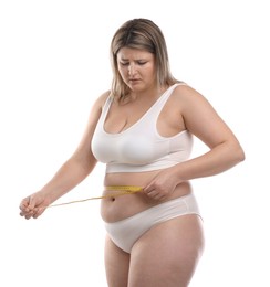 Photo of Weight loss. Plus size woman measuring waist with tape on white background