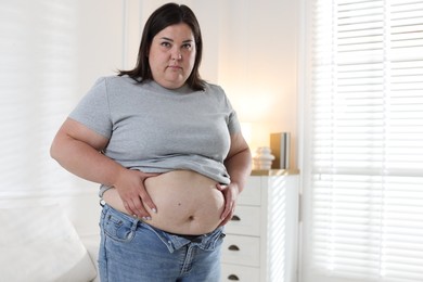 Photo of Woman with excessive belly fat indoors, space for text. Overweight problem