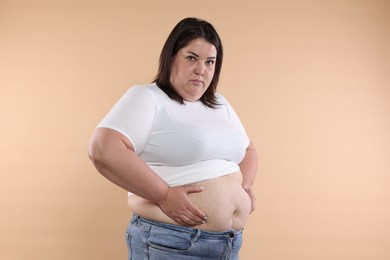 Photo of Woman with excessive belly fat on beige background