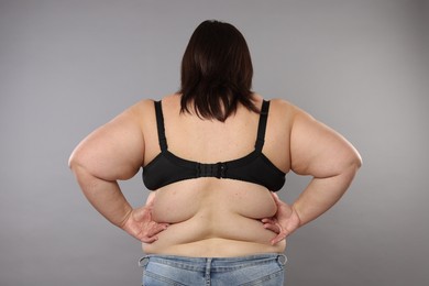 Photo of Overweight woman on grey background, back view