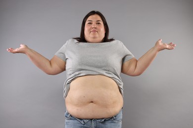 Photo of Woman with excessive belly fat on grey background