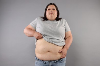 Photo of Woman with excessive belly fat on grey background