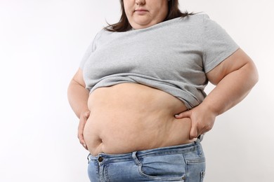 Photo of Woman with excessive belly fat on white background, closeup