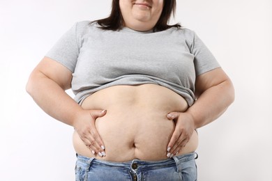 Photo of Woman with excessive belly fat on white background, closeup