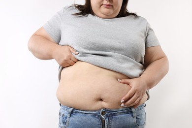 Photo of Woman with excessive belly fat on white background, closeup