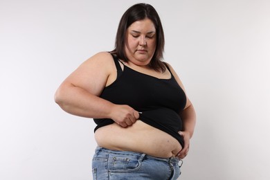 Photo of Woman with excessive belly fat on white background