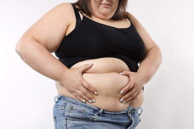 Photo of Woman with excessive belly fat on white background, closeup