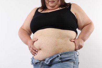 Photo of Woman with excessive belly fat on white background, closeup