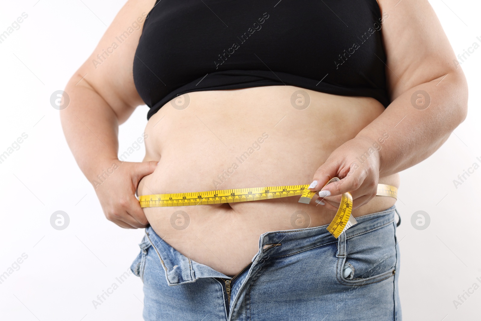 Overweight woman measuring her belly with tape on white background, closeup Photo of Overweight woman measuring her belly with tape on white background, closeup