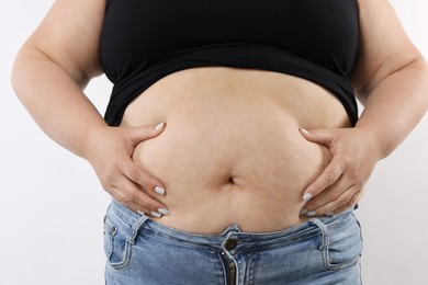 Photo of Woman with excessive belly fat on white background, closeup