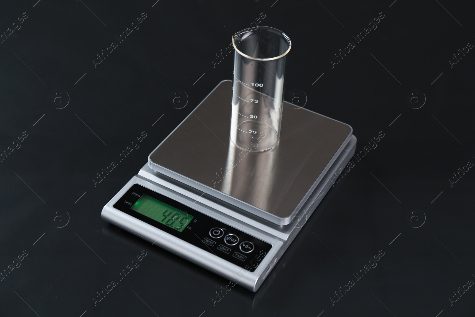 Scale with empty beaker on black mirror table, closeup Photo of Scale with empty beaker on black mirror table, closeup