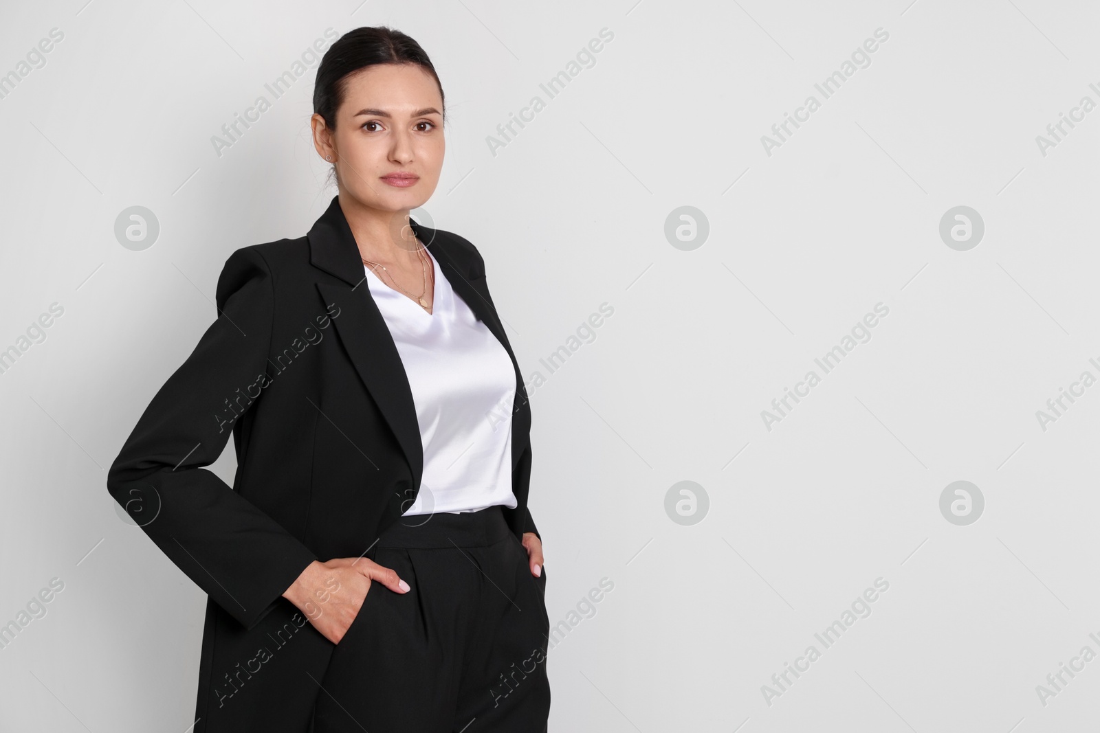 Photo of Confident business woman in suit on light background. Space for text