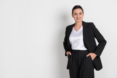 Photo of Confident business woman in suit on light background. Space for text