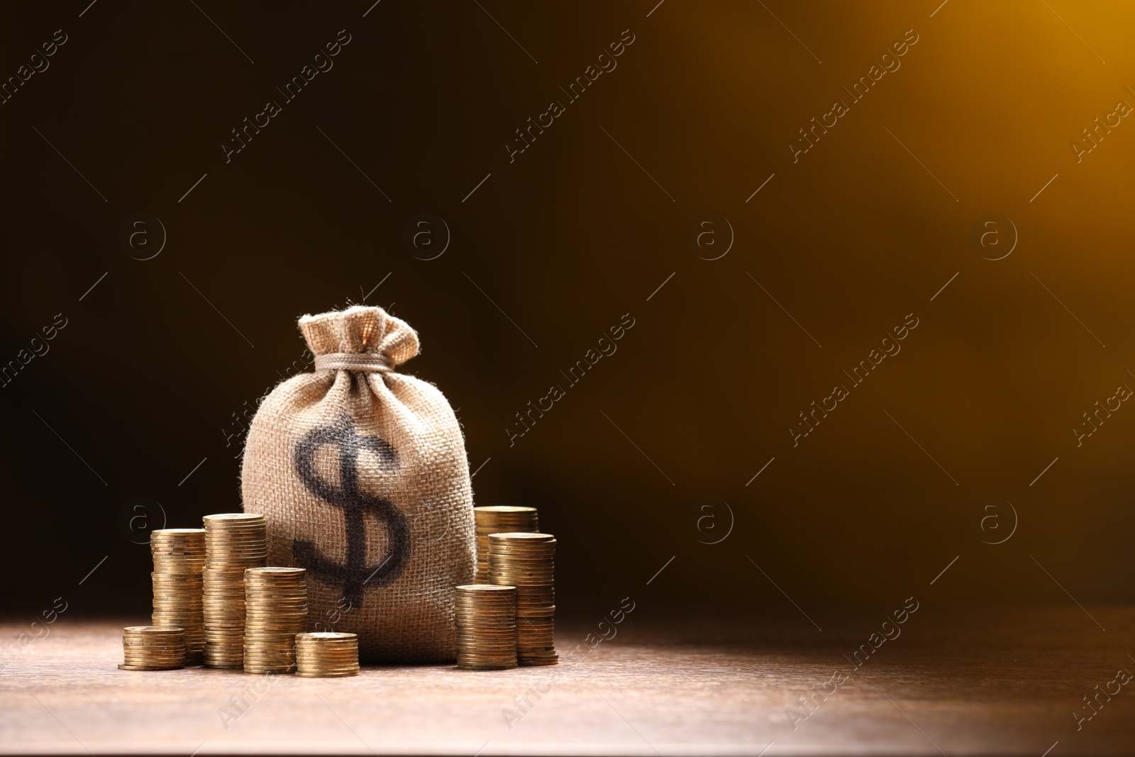 Bag with dollar sign and stacked coins on table against dark color gradient background, space for text Photo of Bag with dollar sign and stacked coins on table against dark color gradient background, space for text