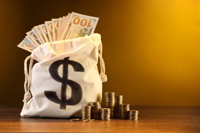 Photo of Bag with dollar banknotes and stacked coins on wooden table against yellow gradient background, space for text