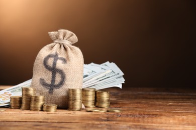 Photo of Bag, dollar banknotes and stacked coins on wooden table against beige gradient background, space for text