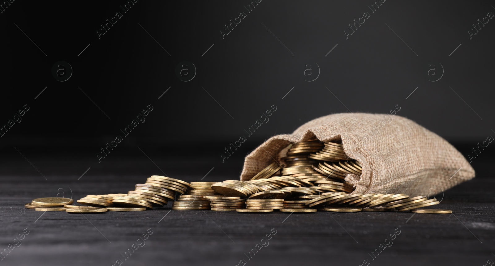 Bag and coins on dark background, closeup Photo of Bag and coins on dark background, closeup