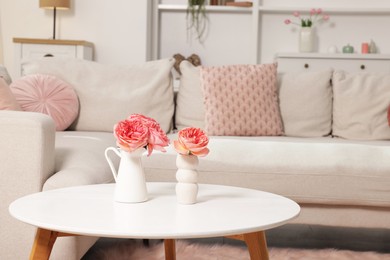 Photo of Cozy living room interior. Side table with flowers and soft sofa indoors
