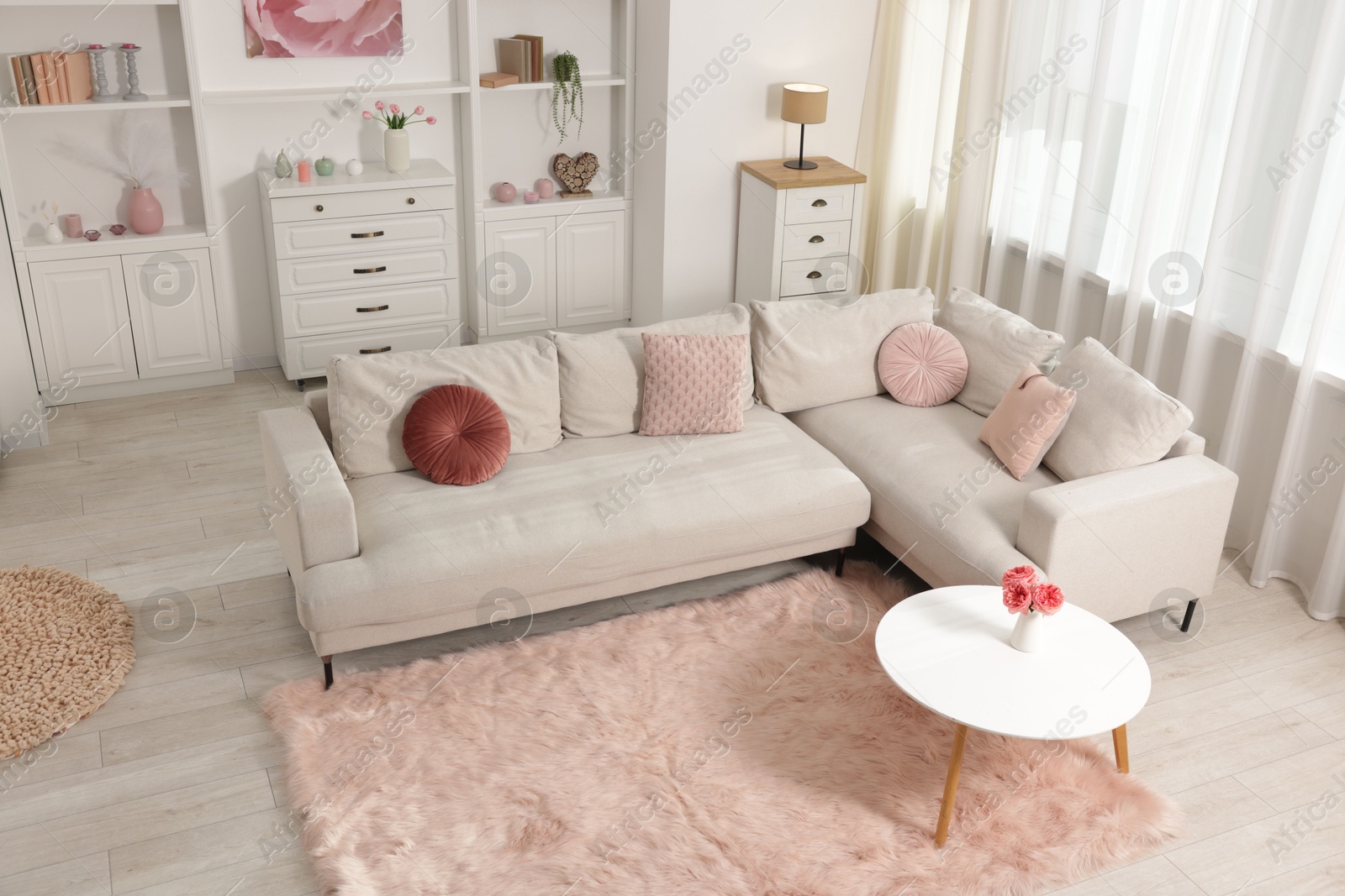 Cozy living room interior. Side table, sofa and shelving unit indoors, above view Photo of Cozy living room interior. Side table, sofa and shelving unit indoors, above view