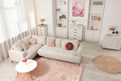 Photo of Cozy living room interior. Side table, sofa and shelving unit indoors, above view