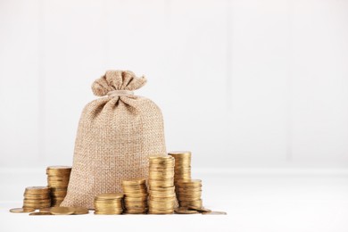 Photo of Bag and stacked coins on white background, space for text