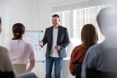 Photo of Man giving public speech in front of audience indoors