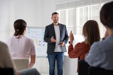 Photo of Man giving public speech in front of audience indoors