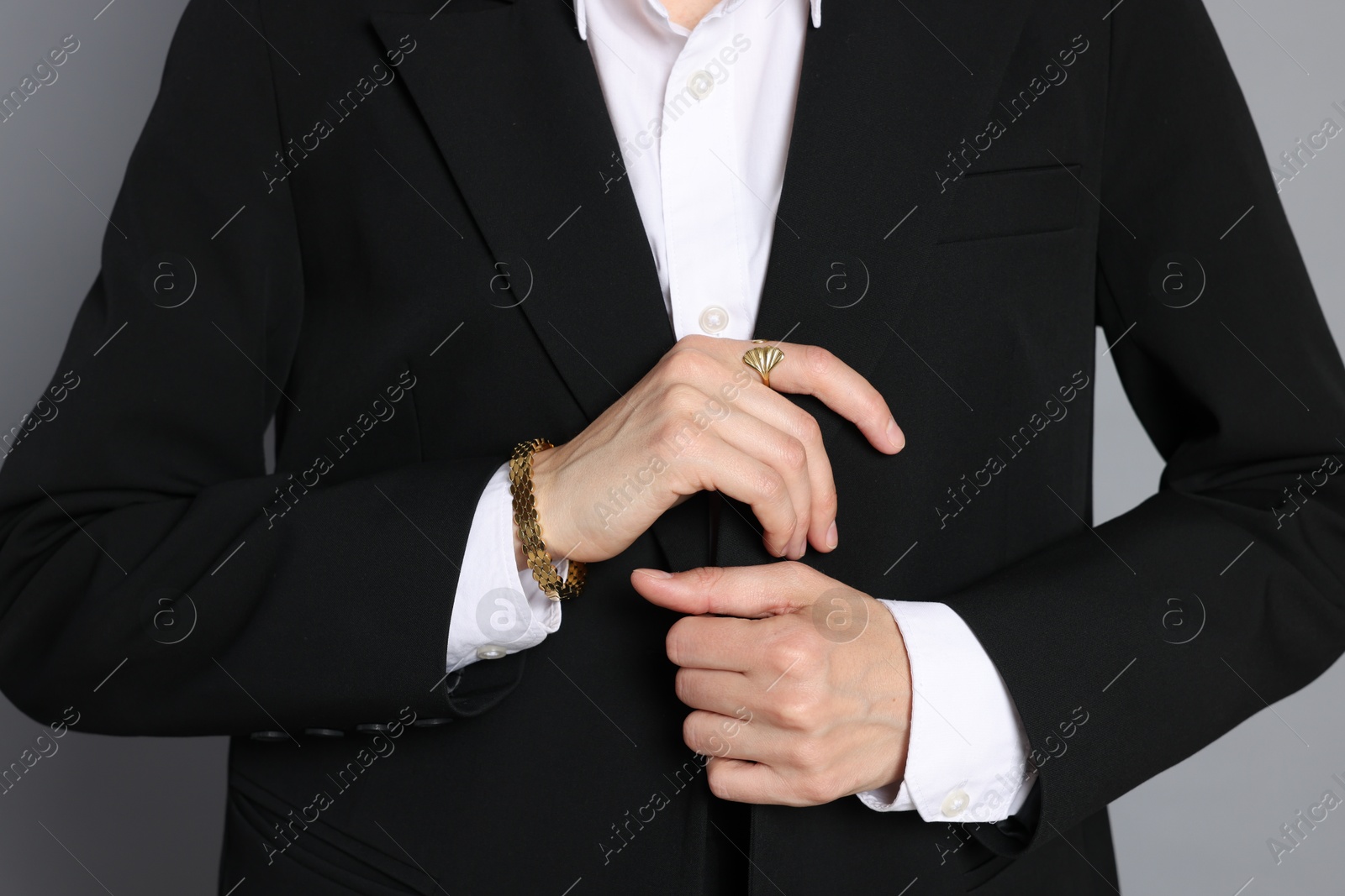 Woman in suit on grey background, closeup Photo of Woman in suit on grey background, closeup