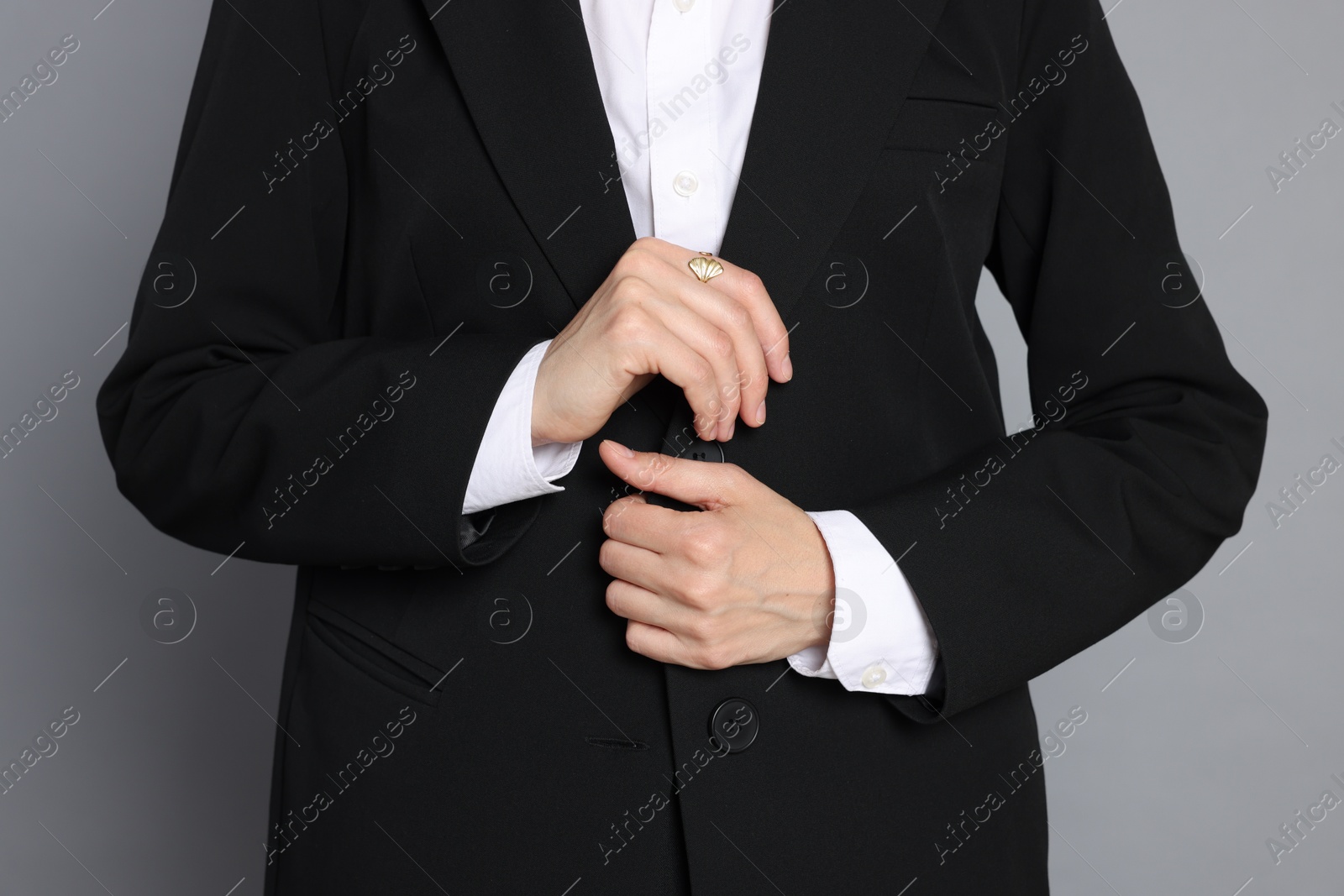 Woman in suit on grey background, closeup Photo of Woman in suit on grey background, closeup
