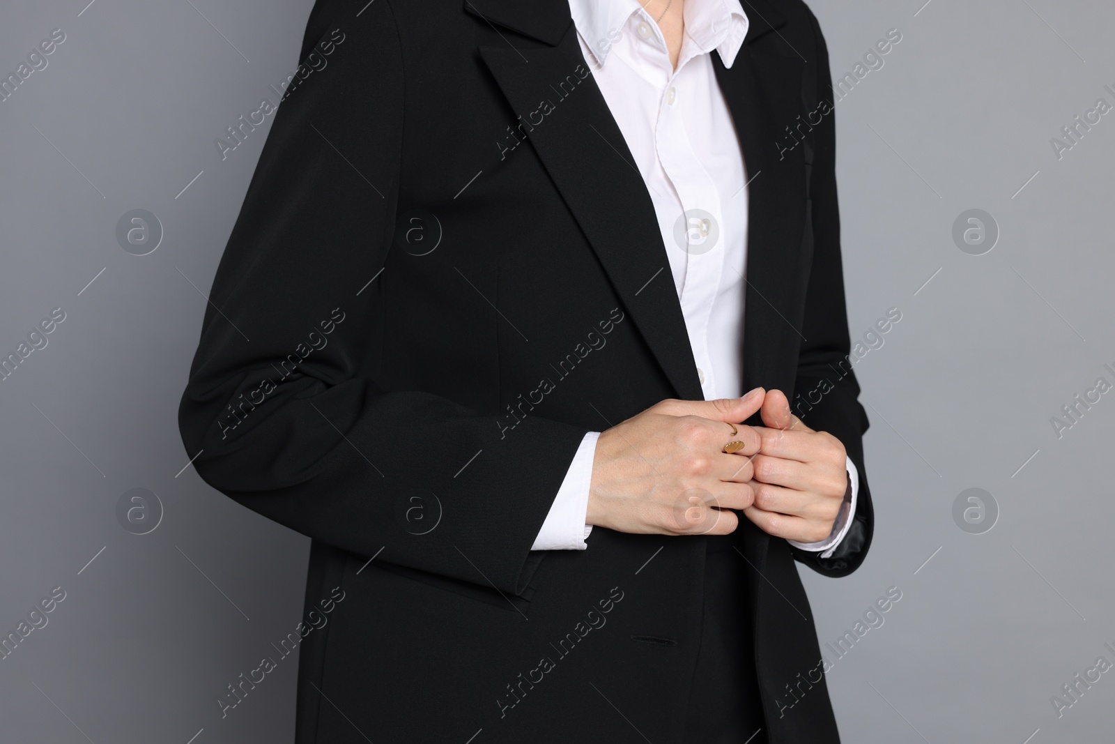 Woman in suit on grey background, closeup Photo of Woman in suit on grey background, closeup