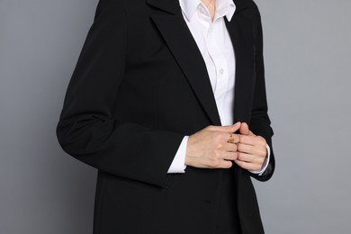 Photo of Woman in suit on grey background, closeup