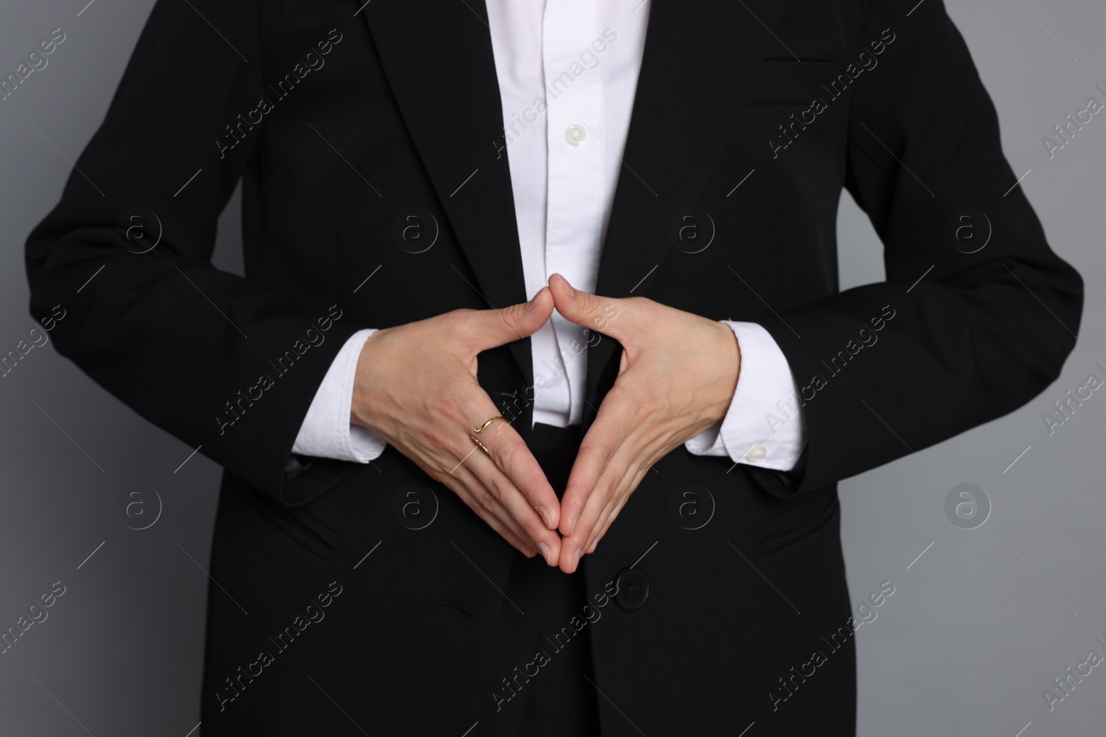 Woman in suit on grey background, closeup Photo of Woman in suit on grey background, closeup